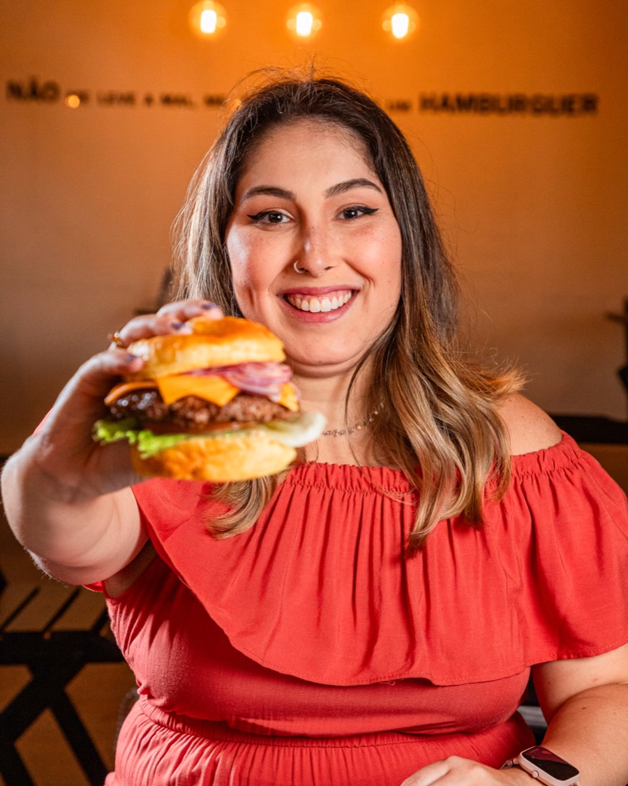 Cliente jovem com burger no salão da Arena